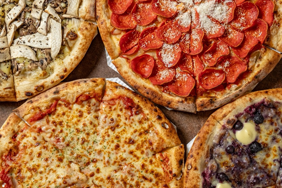 Four wood-fired pizzas seen from above